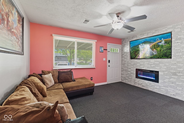 5115 Bertha St, Indianapolis, IN 46241 - living room featuring a large fireplace, a textured ceiling, a ceiling fan, and dark carpet