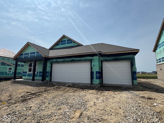 1351 Foxtail Ln, Greenwood, IN 46143 - view of front of house featuring a garage, a shingled roof, and dirt driveway