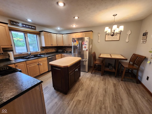 1026 Summer Way Dr, Shelbyville, IN 46176 - kitchen featuring appliances with stainless steel finishes, light wood-type flooring, a chandelier, decorative backsplash, and a sink