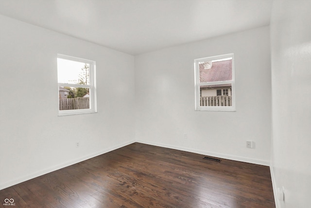 empty room with dark wood-type flooring and baseboards
