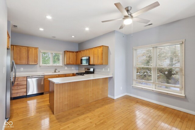455 S Pine St Unit 4, Indianapolis, IN 46203 - kitchen featuring stainless steel appliances, a sink, light wood-type flooring, a peninsula, and light countertops