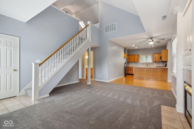 455 S Pine St Unit 4, Indianapolis, IN 46203 - unfurnished living room with light colored carpet, a ceiling fan, stairway, baseboards, and light tile patterned flooring