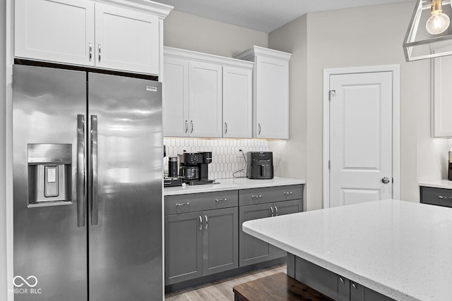 3583 Collier Dr, Lafayette, IN 47905 - kitchen with stainless steel refrigerator with ice dispenser, gray cabinetry, light stone counters, backsplash, and light wood-style flooring