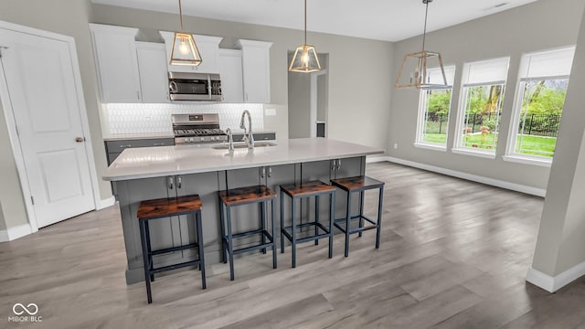 3583 Collier Dr, Lafayette, IN 47905 - kitchen featuring appliances with stainless steel finishes, a sink, baseboards, decorative backsplash, and light wood-style floors