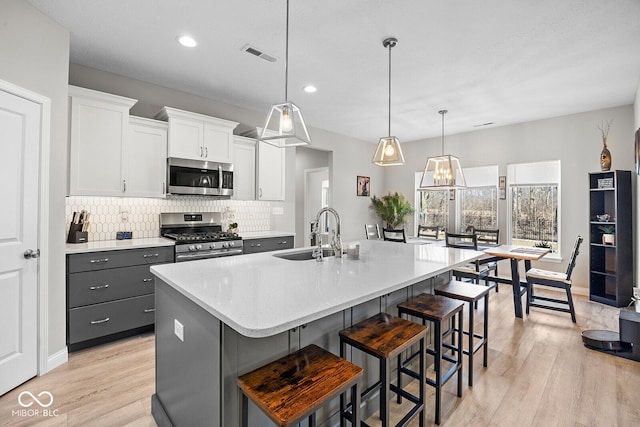 3583 Collier Dr, Lafayette, IN 47905 - kitchen featuring appliances with stainless steel finishes, a sink, backsplash, light wood-type flooring, and recessed lighting