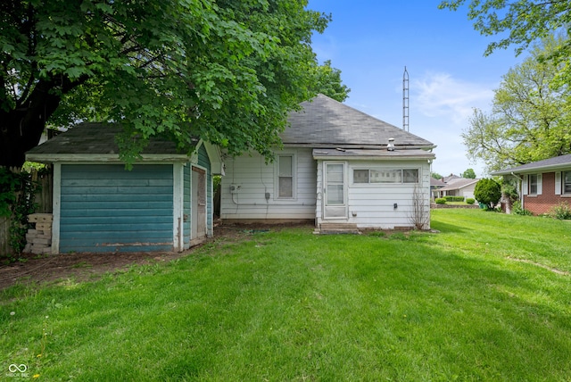 back of property featuring a lawn and a shingled roof
