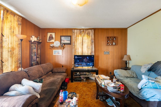 carpeted living area with wood walls and ornamental molding