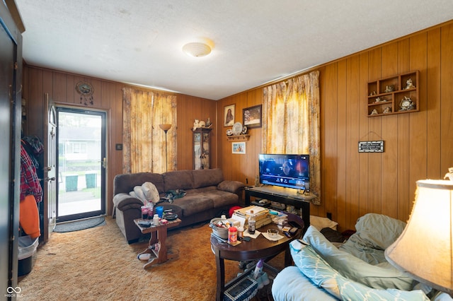 living room featuring wood walls, carpet floors, and a textured ceiling