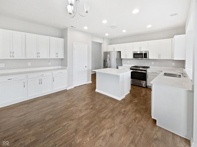 1276 Sanderling Dr, Greenwood, IN 46143 - kitchen with stainless steel appliances, a sink, dark wood-type flooring, white cabinetry, and a center island