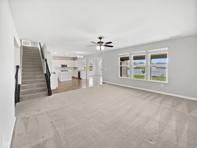 1276 Sanderling Dr, Greenwood, IN 46143 - unfurnished living room featuring a ceiling fan, light colored carpet, baseboards, recessed lighting, and stairs