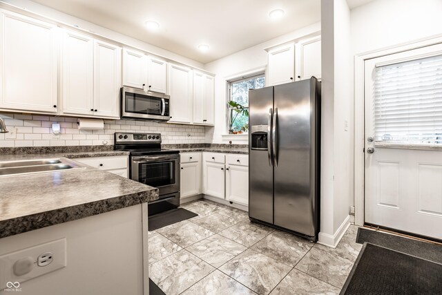 3047 N New Jersey St, Indianapolis, IN 46205 - kitchen featuring stainless steel appliances, a sink, dark countertops, white cabinets, and backsplash