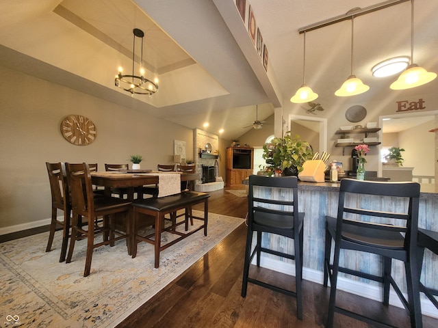 1714 Michelle Mnr, Danville, IN 46122 - dining room featuring dark wood-style flooring, lofted ceiling, a ceiling fan, a large fireplace, and a chandelier