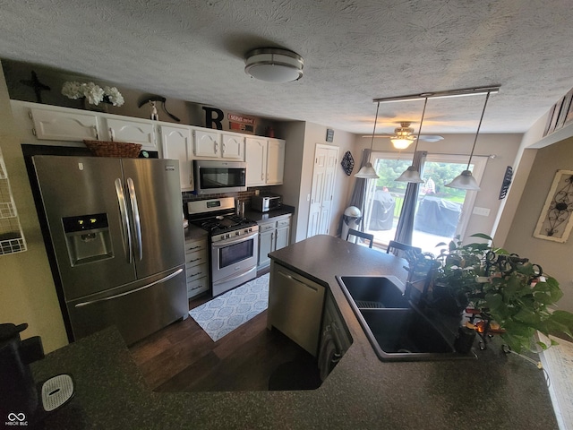 1714 Michelle Mnr, Danville, IN 46122 - kitchen with appliances with stainless steel finishes, dark countertops, a sink, white cabinets, and dark wood-style floors
