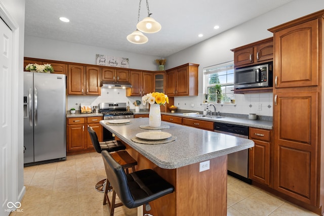 3449 Brixford Ln, West Lafayette, IN 47906 - kitchen featuring stainless steel appliances, under cabinet range hood, a sink, a breakfast bar, and light tile patterned floors