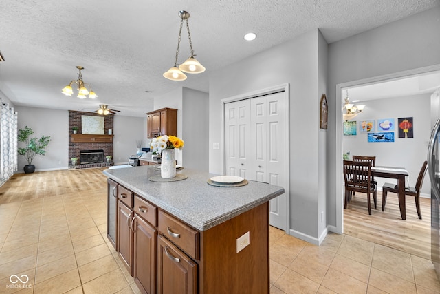 3449 Brixford Ln, West Lafayette, IN 47906 - kitchen with a chandelier, light tile patterned floors, a textured ceiling, brown cabinetry, and a center island