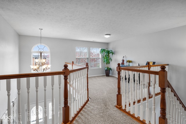 3449 Brixford Ln, West Lafayette, IN 47906 - hallway with an upstairs landing, a chandelier, carpet floors, baseboards, and a textured ceiling