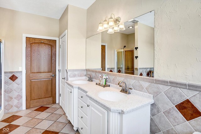 186 W 600 N, Alexandria, IN 46001 - full bath featuring tile walls, a stall shower, wainscoting, double vanity, and a chandelier