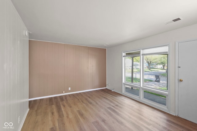 611 Hampton Ln, Anderson, IN 46017 - spare room with light wood-type flooring, baseboards, and wooden walls