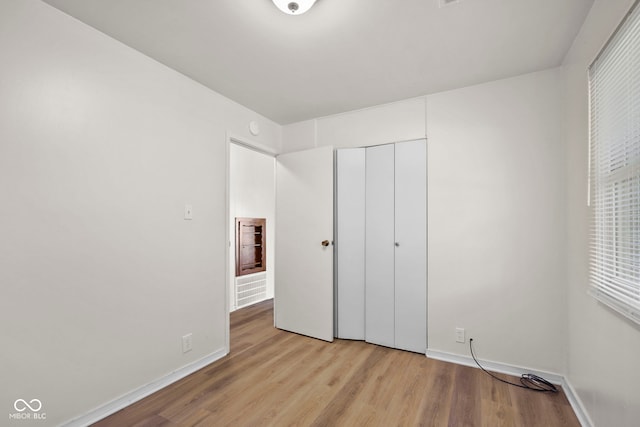611 Hampton Ln, Anderson, IN 46017 - unfurnished bedroom with light wood finished floors, baseboards, and a closet