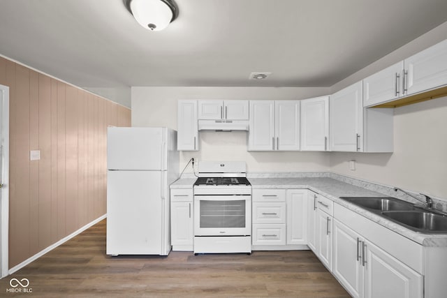 611 Hampton Ln, Anderson, IN 46017 - kitchen with white appliances, a sink, white cabinets, under cabinet range hood, and wooden walls