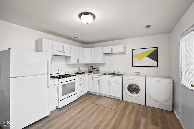 611 Hampton Ln, Anderson, IN 46017 - kitchen featuring white appliances, independent washer and dryer, under cabinet range hood, a sink, and light wood-style flooring