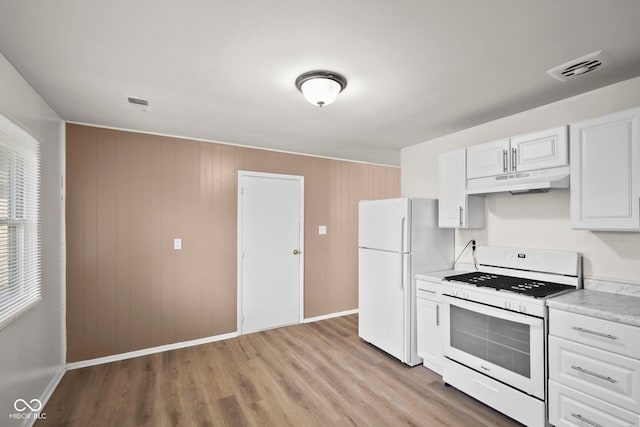 611 Hampton Ln, Anderson, IN 46017 - kitchen with white appliances, under cabinet range hood, light countertops, baseboards, and light wood-style flooring