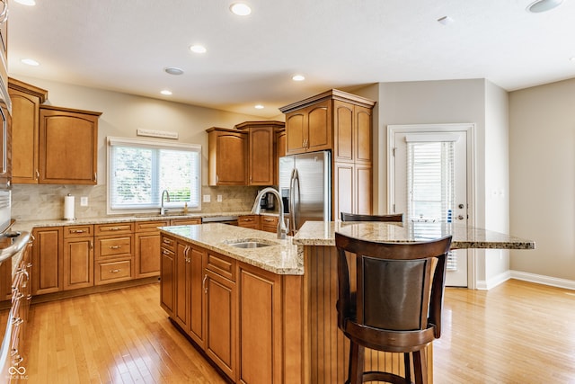 10784 Giselle Way, Fishers, IN 46040 - kitchen featuring a sink, appliances with stainless steel finishes, light wood-type flooring, a breakfast bar, and recessed lighting