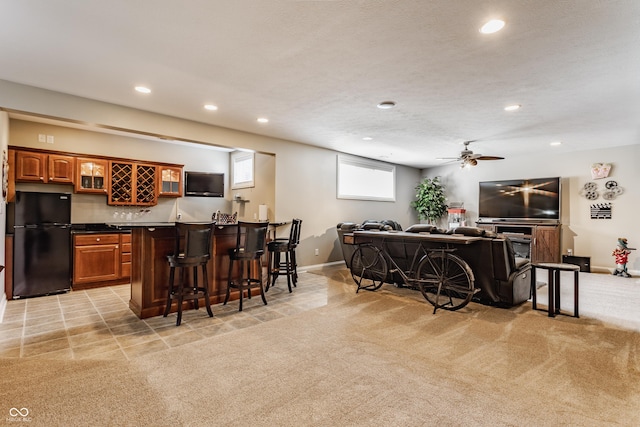 10784 Giselle Way, Fishers, IN 46040 - kitchen with freestanding refrigerator, a breakfast bar, recessed lighting, glass insert cabinets, and a peninsula