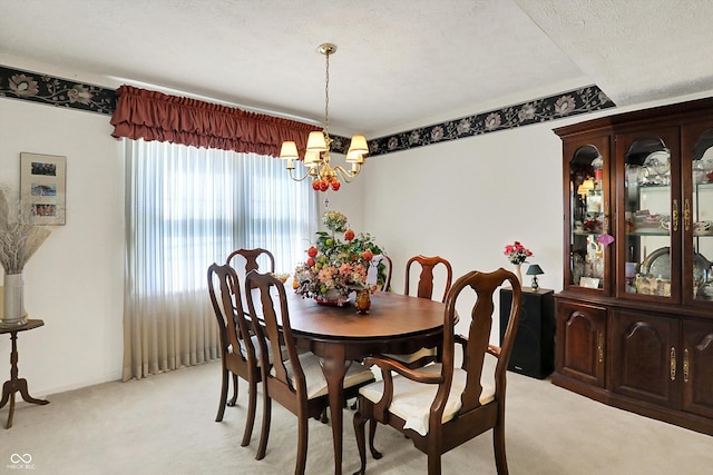 dining area with light colored carpet, a chandelier, a textured ceiling, and baseboards