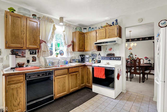 kitchen with white appliances, under cabinet range hood, a chandelier, and light countertops