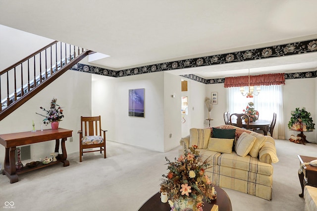 living room featuring carpet flooring, a chandelier, and stairs