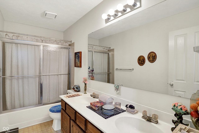 bathroom featuring toilet, enclosed tub / shower combo, and double vanity
