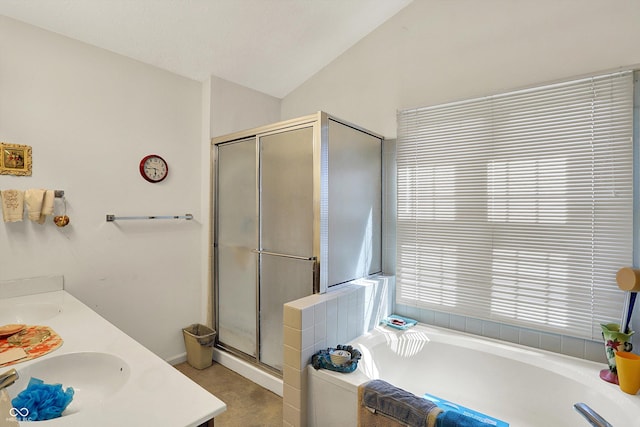 bathroom featuring lofted ceiling, a shower stall, a bath, and double vanity