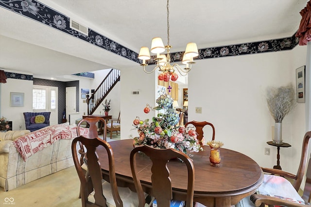 dining room featuring a chandelier, stairs, and finished concrete flooring