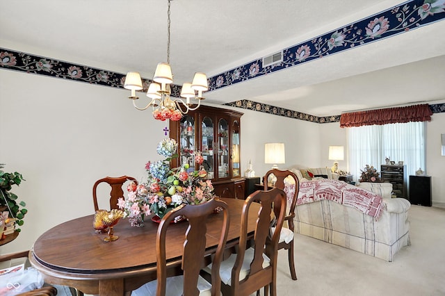dining space with a chandelier and light colored carpet