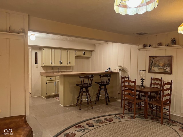 7440 Sylvan Ridge Rd, Indianapolis, IN 46240 - kitchen featuring a breakfast bar area, light tile patterned floors, a peninsula, and light countertops