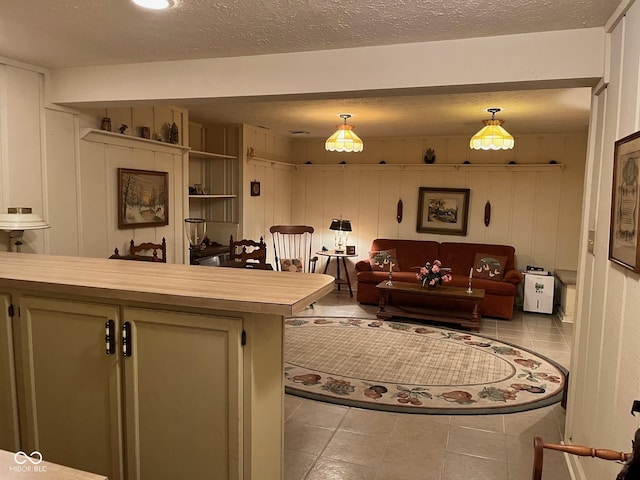 7440 Sylvan Ridge Rd, Indianapolis, IN 46240 - kitchen featuring decorative light fixtures, open floor plan, wooden counters, a textured ceiling, and tile patterned floors