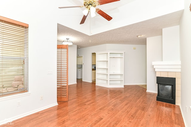 1030 Longwell Pl, Indianapolis, IN 46240 - unfurnished living room with a ceiling fan, a tile fireplace, light wood-type flooring, and baseboards