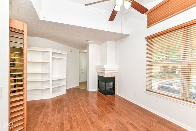1030 Longwell Pl, Indianapolis, IN 46240 - unfurnished living room featuring wood finished floors, a tile fireplace, ceiling fan, baseboards, and vaulted ceiling