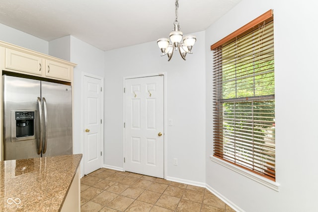 1030 Longwell Pl, Indianapolis, IN 46240 - kitchen featuring stainless steel fridge, a chandelier, cream cabinets, baseboards, and pendant lighting