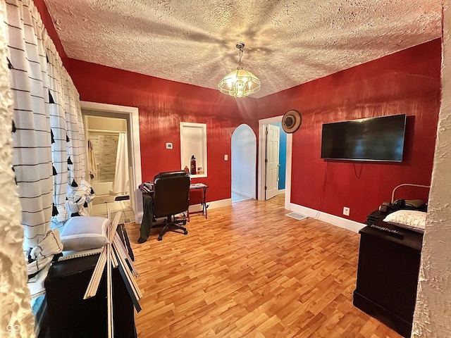 1332 W 26th St, Indianapolis, IN 46208 - living area featuring arched walkways, light wood-type flooring, baseboards, and a textured ceiling