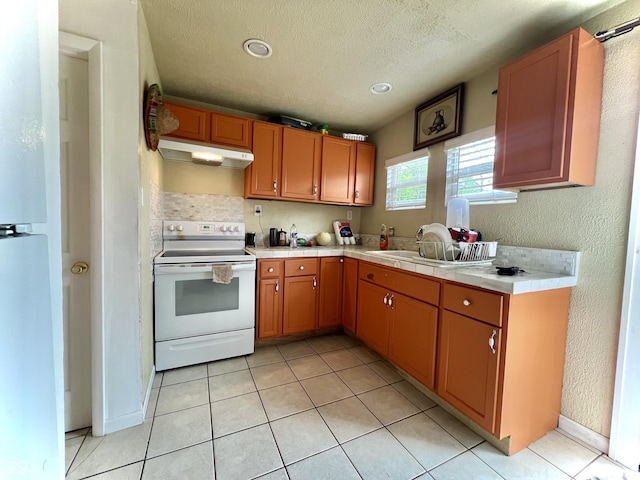 1332 W 26th St, Indianapolis, IN 46208 - kitchen with white electric range oven, under cabinet range hood, light tile patterned floors, a textured ceiling, and tile counters
