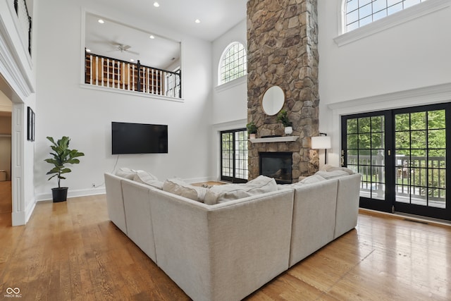 1478 W 500 S, Peru, IN 46970 - living area with a towering ceiling, a fireplace, plenty of natural light, ceiling fan, and light wood-style flooring