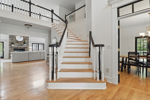 1478 W 500 S, Peru, IN 46970 - stairway with a chandelier, a towering ceiling, wood finished floors, baseboards, and a stone fireplace