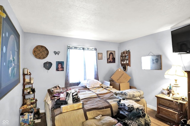 2200 N Dixon Rd, Kokomo, IN 46901 - bedroom featuring wood finished floors, a textured ceiling, and baseboards