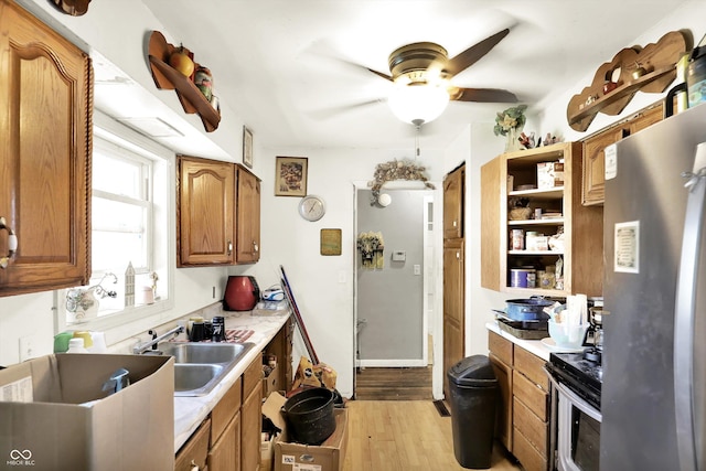2200 N Dixon Rd, Kokomo, IN 46901 - kitchen with a sink, stainless steel appliances, light wood finished floors, brown cabinetry, and ceiling fan