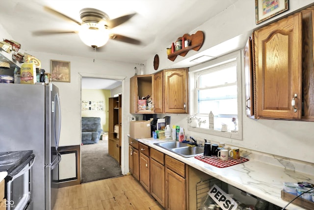 2200 N Dixon Rd, Kokomo, IN 46901 - kitchen with a ceiling fan, appliances with stainless steel finishes, light countertops, a sink, and light wood-type flooring