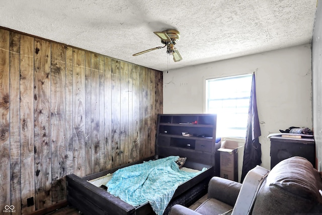 2200 N Dixon Rd, Kokomo, IN 46901 - bedroom with wood walls, a textured ceiling, and a ceiling fan