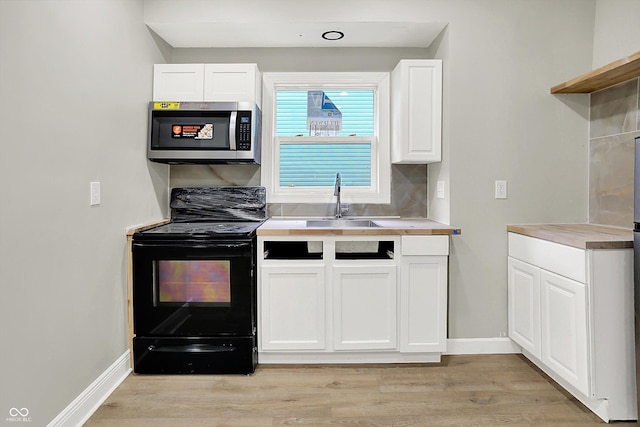 1033 N Dearborn St, Indianapolis, IN 46201 - kitchen featuring electric range, stainless steel microwave, a sink, white cabinetry, and light countertops