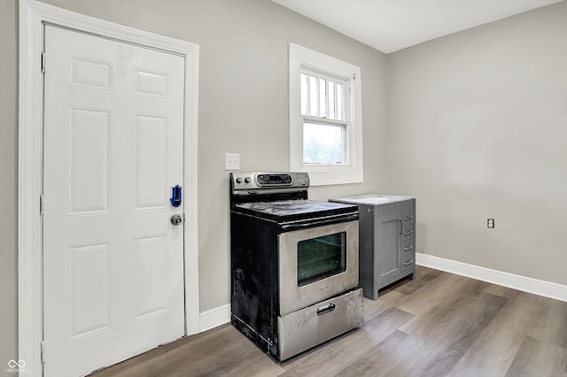1033 N Dearborn St, Indianapolis, IN 46201 - kitchen with electric range, baseboards, wood finished floors, and light countertops